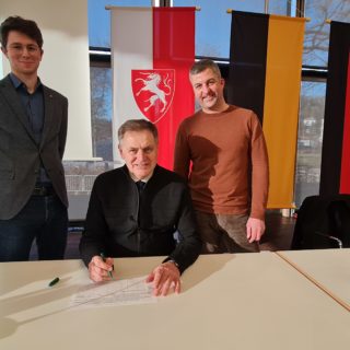 OB Richard Arnold unterzeichnet, flankiert von den Stadträten Tim Luka Schwab (links) und Sebastian Fritz (rechts).© privat